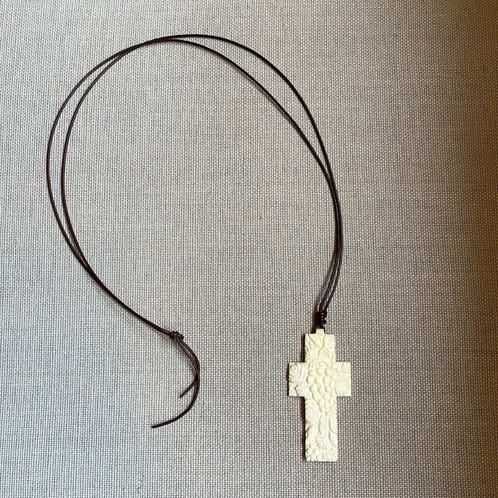 Ivory cross necklace on a brown leather cord